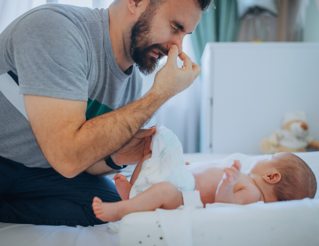 Father changing newborn baby diaper while engaging in caregiving interaction that supports infant brain growth