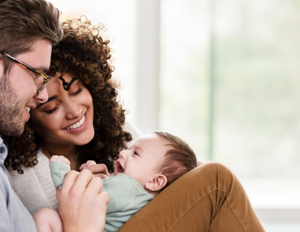 Parents smiling and talking with newborn baby during bonding moment supporting early brain development