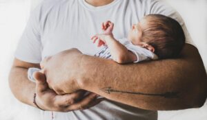 father-holding-newborn-baby-on-forearm-postpartum-bondingjpg-1