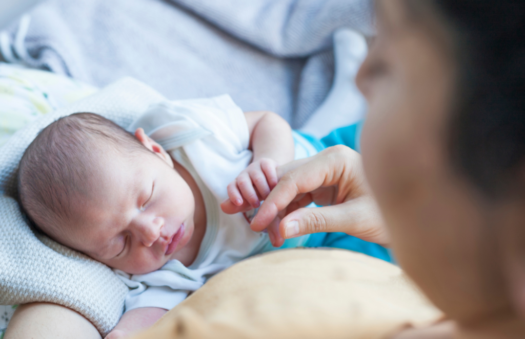 Newborn baby sleeping peacefully during a gentle bedtime ritual on mothers arms